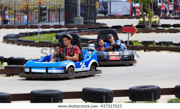 VALLEJO, CALIFORNIA, USA - JUNE 14, 2016:  Six\
Flags theme park,  dad and son driving Thunder Road Speedway\
Go-Karts racing\
track\
