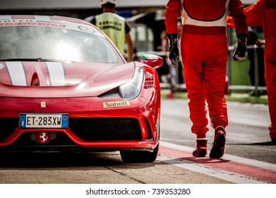 Vallelunga, Italy September 24 2017. Ferrari Driver In Red Race Suit Walking Near Red Car In Motorsport Circuit Pit Lane Low Section View