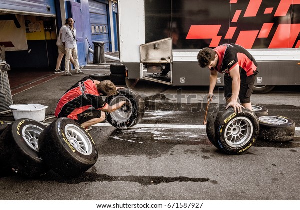 Vallelunga,\
Rome, Italy. June 24 2017. Couple of mechanics working in circuit\
pit cleaning and washing racing tires\
set