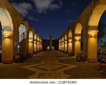 Valletta, Malta - November 10th 2020: The terraced arches lit up at night leading to the Clement Martin Edwards Monument at the Upper Barrakka Garden.