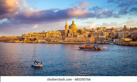 Valletta, Malta - Sail boats at the walls of Valletta with Saint Paul's Cathedral and beautiful sky and clouds in the morning