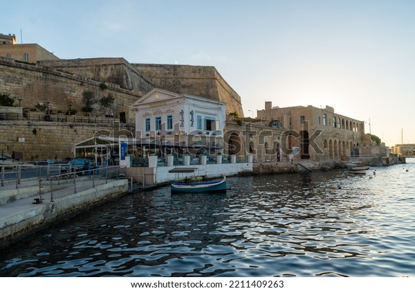 Valletta, Malta - September 13th\
2022: The former Harbour Police Station now a restaurant on the\
banks of Marsamxett Harbour. In the background is St. Andrews\
Bastion.
