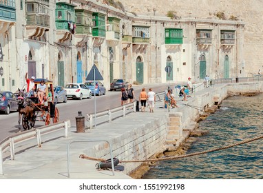 VALLETTA, MALTA: Waterfront Of Old City With Horse Cart And Some Older Men Fishing On A Fishing Rods On 1 October, 2019. Valletta City Is A World Heritage Site By UNESCO From 1980