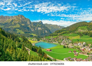 Valley of Engelberg with Eugenisee lake. View from cable car to Titlis mountain of the Uri Alps. Located in cantons of Obwalden and Bern, Switzerland, Europe. Summer season, clear blue sky.