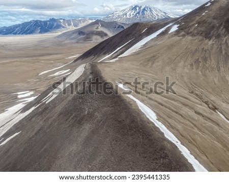 The Valley of Ten Thousand Smokes in Katmai National Park and Preserve in Alaska is filled with ash flow from Novarupta eruption in 1912. Aerial view of ash filled valley between mountains.