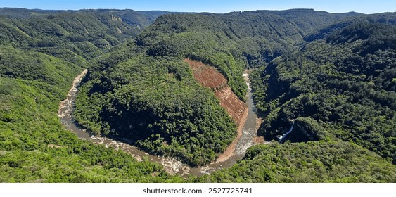 Valley where the Cai River makes a turn around the mountain forming a horseshoe. Dense forest with many araucarias, a small waterfall runs on the right side of the river. Landslides - Powered by Shutterstock