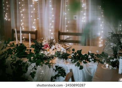 Valmiera, Latvia- July 28, 2024 - Elegant table setting with a floral centerpiece, candles, and fairy lights, creating a festive and cozy atmosphere. - Powered by Shutterstock