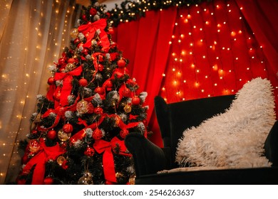 Valmiera, Latvia- November 15, 2024 - Christmas tree decorated with red bows and ornaments next to a cozy armchair with a fluffy blanket, set against a backdrop of warm string lights. - Powered by Shutterstock