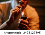 Valmiera, Latvia - September 9, 2023 -  Close-up of a person lighting a cigar with a lighter, showcasing a detailed and intimate moment of cigar smoking.