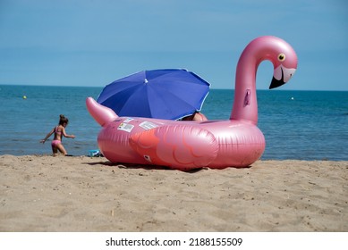 Valras - France - 26 July 2022 - View of pink buoy in shaped flamingo on the beach