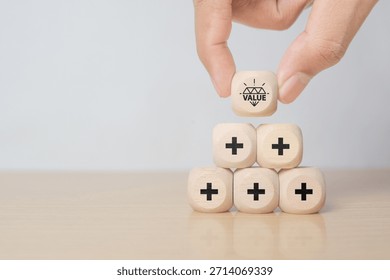 Value added concept. Way to adding value to product and service. Hand choose wooden blocks with value added icons. Improving products, excellent service, expert advice, consistently upgrade, deliver fast
