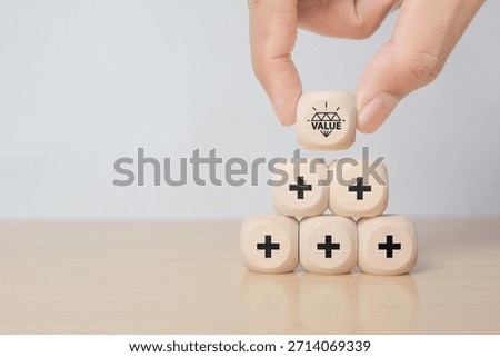 Value added concept. Way to adding value to product and service. Hand choose wooden blocks with value added icons. Improving products, excellent service, expert advice, consistently upgrade, deliver fast