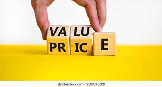 Value and price symbol. Businessman turns wooden cubes and changes the word price to value or vice versa. Beautiful yellow table, white background, copy space. Business value and price concept. - Shutterstock ID 2109743600