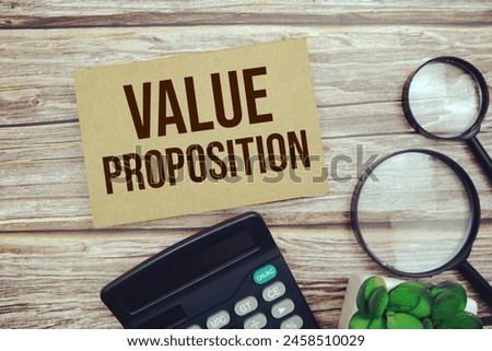 Value Proposition text message with calculator and magnifying top view on wooden background