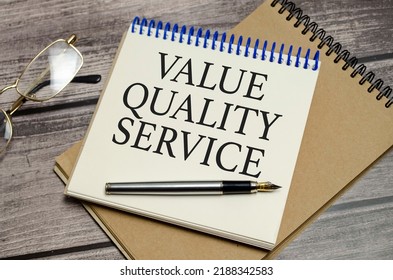 Value Quality Service Symbol On Notepad And Glasses And Pen