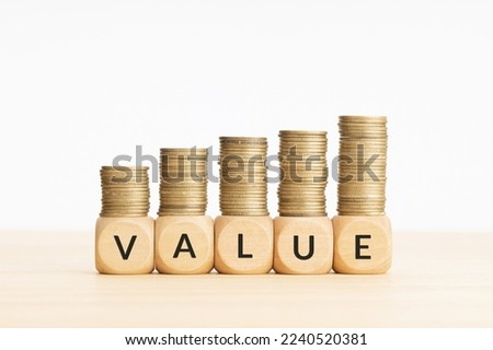 Value word on wooden blocks and rising stacked coins. Copy space