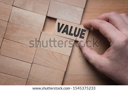 Value word written on wooden block. Add value to your business concept.