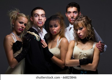 Vampire Family Posing On A Gray Background