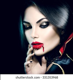Vampire Halloween Woman portrait. Beauty Sexy Vampire Girl with  dripping blood on her mouth. Vampire makeup Fashion Art design. Attractive model girl in Halloween costume and make up 