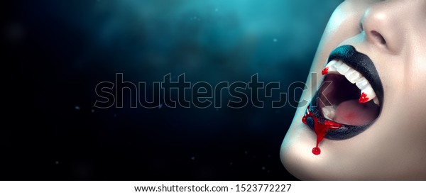 Vampire teeth with\
dripping blood, Woman\'s black bloody lips close-up. Fashion\
Halloween art design. Close up of female vampire mouth, teeth. On\
black scary background