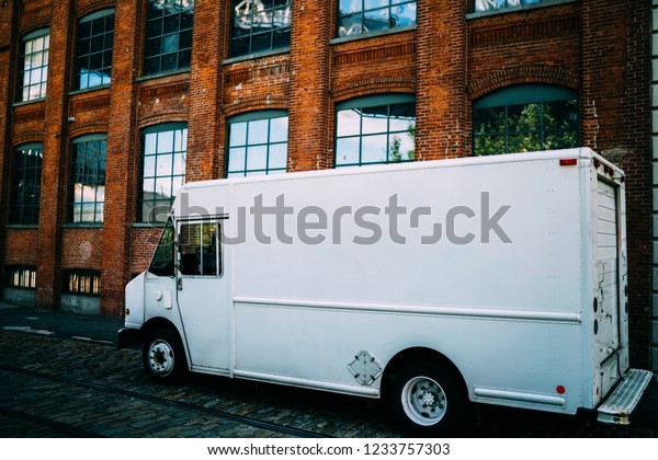 Van automobile of service company transporting\
and delivering goods parked on city street, white postal cargo with\
copy space area for advertising content or commerce information\
used for relocation