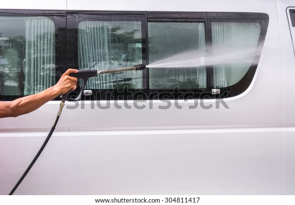 Van\
Car wash by high pressure cleaners, focus on the\
car