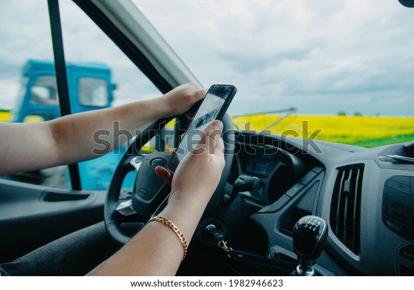 van driver uses smartphone while taking delivery\
order, car driver