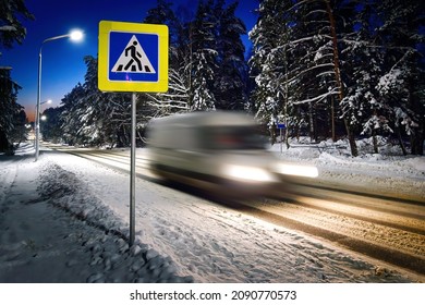 Van Driving Fast Through Pedestrian Crossing On Snowy Country Road At Night Time. Car With Headlights Rush Through Pedestrian Crossing, Motion Blur Effect. Night Rural Snowy Road With Driving Car.