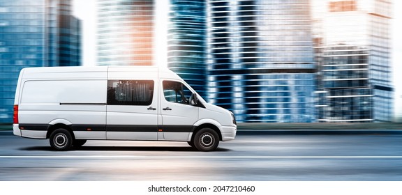 Van Driving On A City Road At Sunset In Front Of A Modern Cityscape