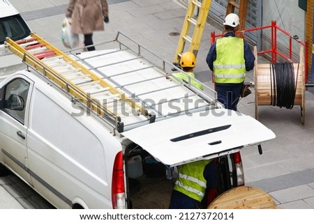 van of electrician workers for install optical fiber cable for internet and phone  lines  in city street