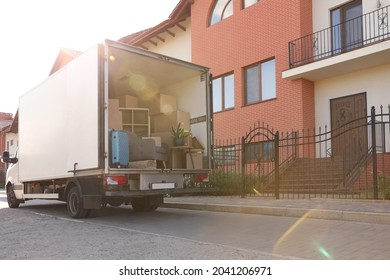 Van Full Of Moving Boxes And Furniture Near House