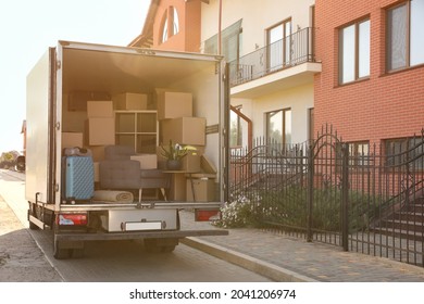 Van full of moving boxes and furniture near house - Shutterstock ID 2041206974