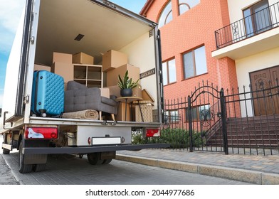 Van Full Of Moving Boxes And Furniture Near House