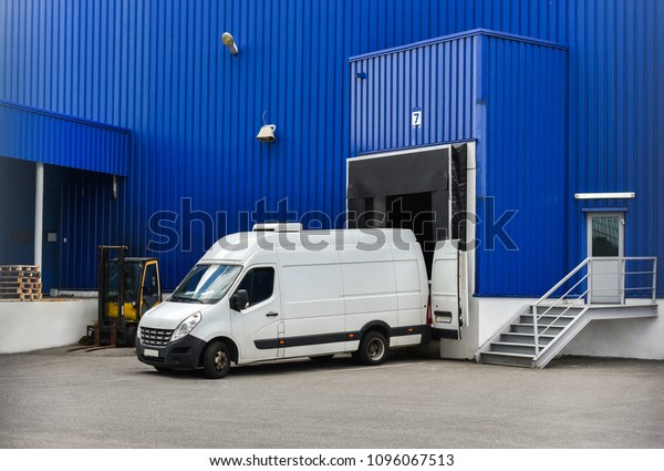 van in loading and unloading commercial cargo in\
warehouse dock