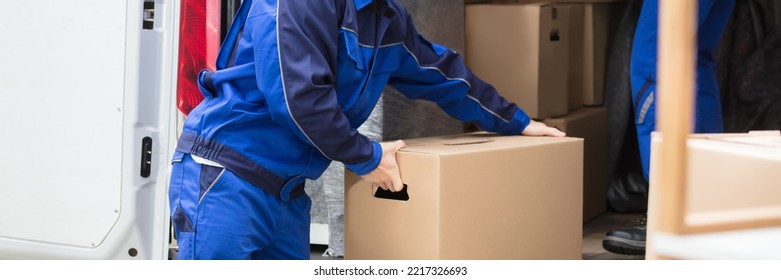 Van Movers Unloading Cardboard Boxes From Delivery Truck