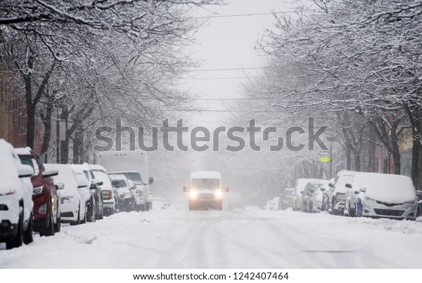 A van\
moves along a snow covered street in\
Montreal
