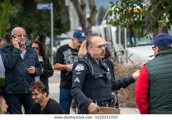 Van Nuys,\
California / USA  - January 19, 2020: A LAPD Traffic officer makes\
a traffic accident investigation by interviewing witnesses and\
drivers in front of 6750 Balboa\
Blvd.