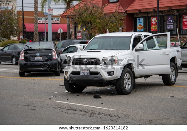 Van Nuys,\
California / USA  - January 19, 2020: A white Toyota Tacoma truck\
sits in the middle of the road after an accident in front of 6750\
Balboa Blvd, viewed from the\
front.