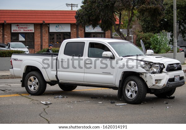 Van Nuys,\
California / USA  - January 19, 2020: A white Toyota Tacoma truck\
sits in the middle of the road after an accident in front of 6750\
Balboa Blvd, viewed from the\
side.