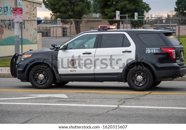 Van Nuys, California / USA  - January 19, 2020: A\
LAPD Traffic patrol vehicle sits in the middle of the road at a\
traffic accident investigation near witnesses and drivers in front\
of 6750 Balboa Blvd