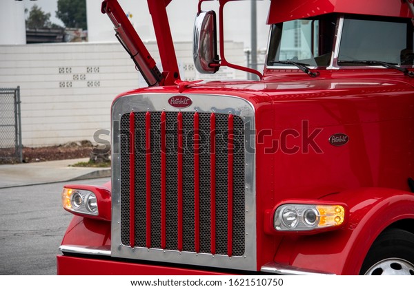Van Nuys,\
California / USA  - January 20, 2020: A red Peterbuilt truck\
car-carrier owned by Pete\'s Auto Transport making a wide turn in\
front of the Budweiser Brewery Gate\
2.