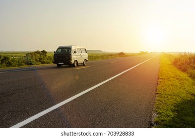 Van On The Road With Yellow Lines At Sunrise