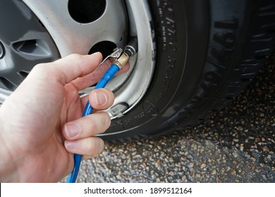 Van tyre pressure checking and inflating with hose on petrol station - Shutterstock ID 1899512164