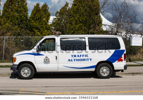 Vancouver, BC, Canada,\
03.29.2021 A white traffic authority van, parked on the curb in a\
covid test facility.