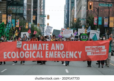 Vancouver, BC, Canada - August 21, 2021: "Extinction Rebellion" protestors march with a banner at a climate change protest 