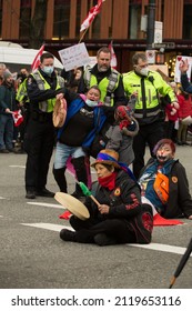 Vancouver, BC, Canada, February 5, 2022, The Indigenous People Sitting In The Burrard Street In Front Of The Traffic With The Drums, At The Freedom Convoy Event, With The Policemen On The Background