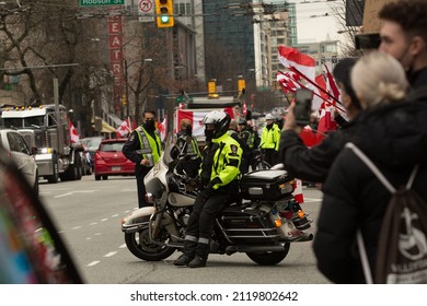 Vancouver, BC, Canada, February 5, 2022, The Policeman Sitting On The Motorbike Among The Crowd That Is Welcoming The Freedom Convoy In Downtown, Guarded By The Weaponized Police