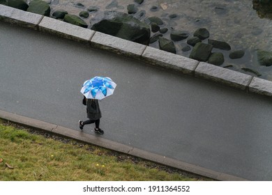 Vancouver BC Canada. February 5,2021.walking People With Butterfly Logo Umbrella On Sea Wall