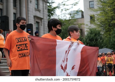 Vancouver, BC, Canada - July 1, 2021: First Nations Children Hold A Critically Stylized Canadian Flag At A 