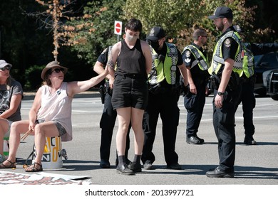 Vancouver, BC, Canada - July 24, 2021:  Vancouver Police officers arrest an activist at an "Extinction Rebellion" climate change protest in front of the Burrard Street Bridge